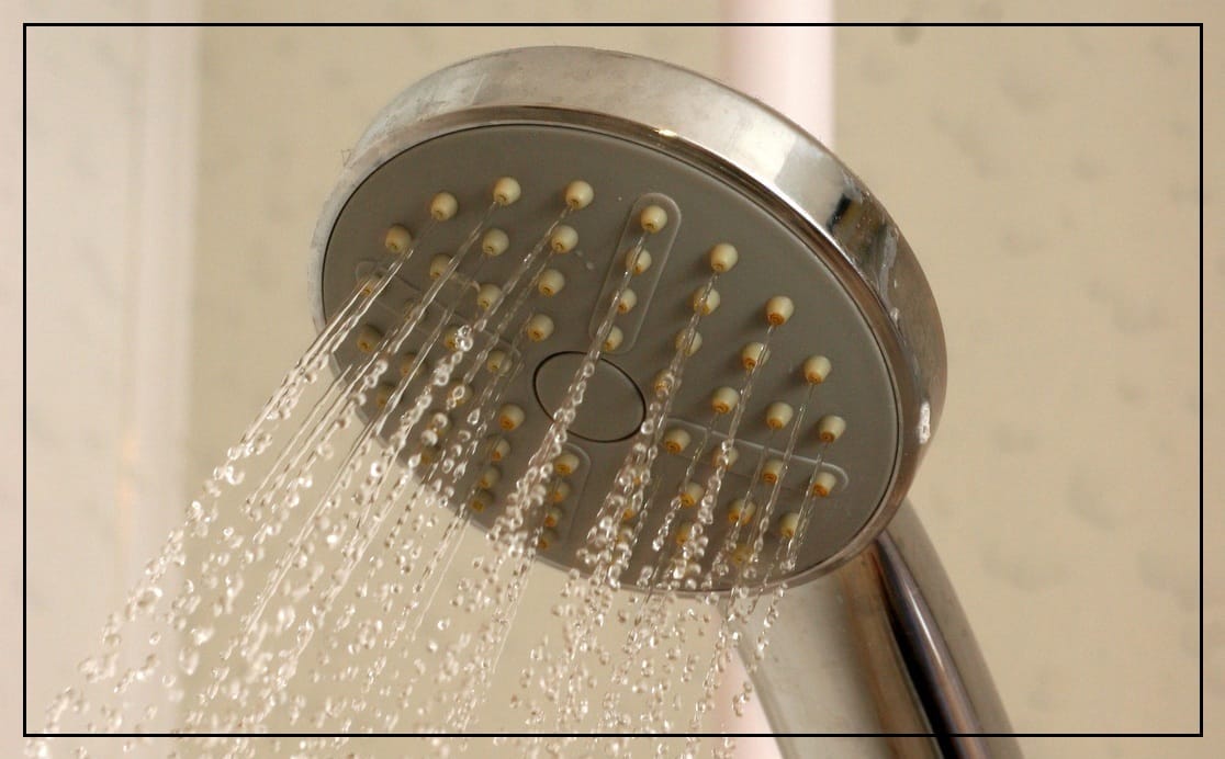 A hand-held shower head with water coming out.